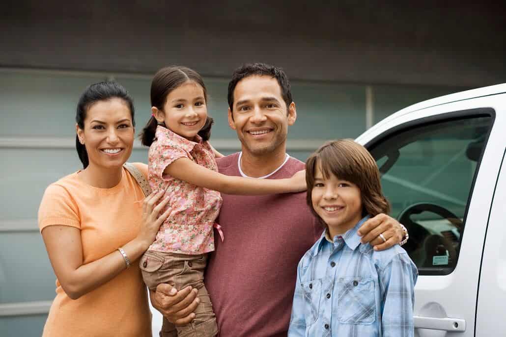 Family of four next to a car