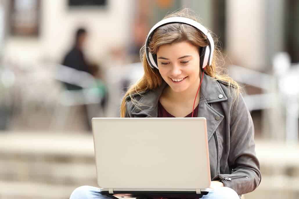 girl wearing headphones on laptop