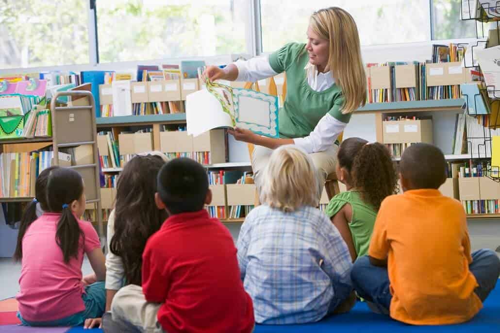 Teacher reading a book to children in a classroom