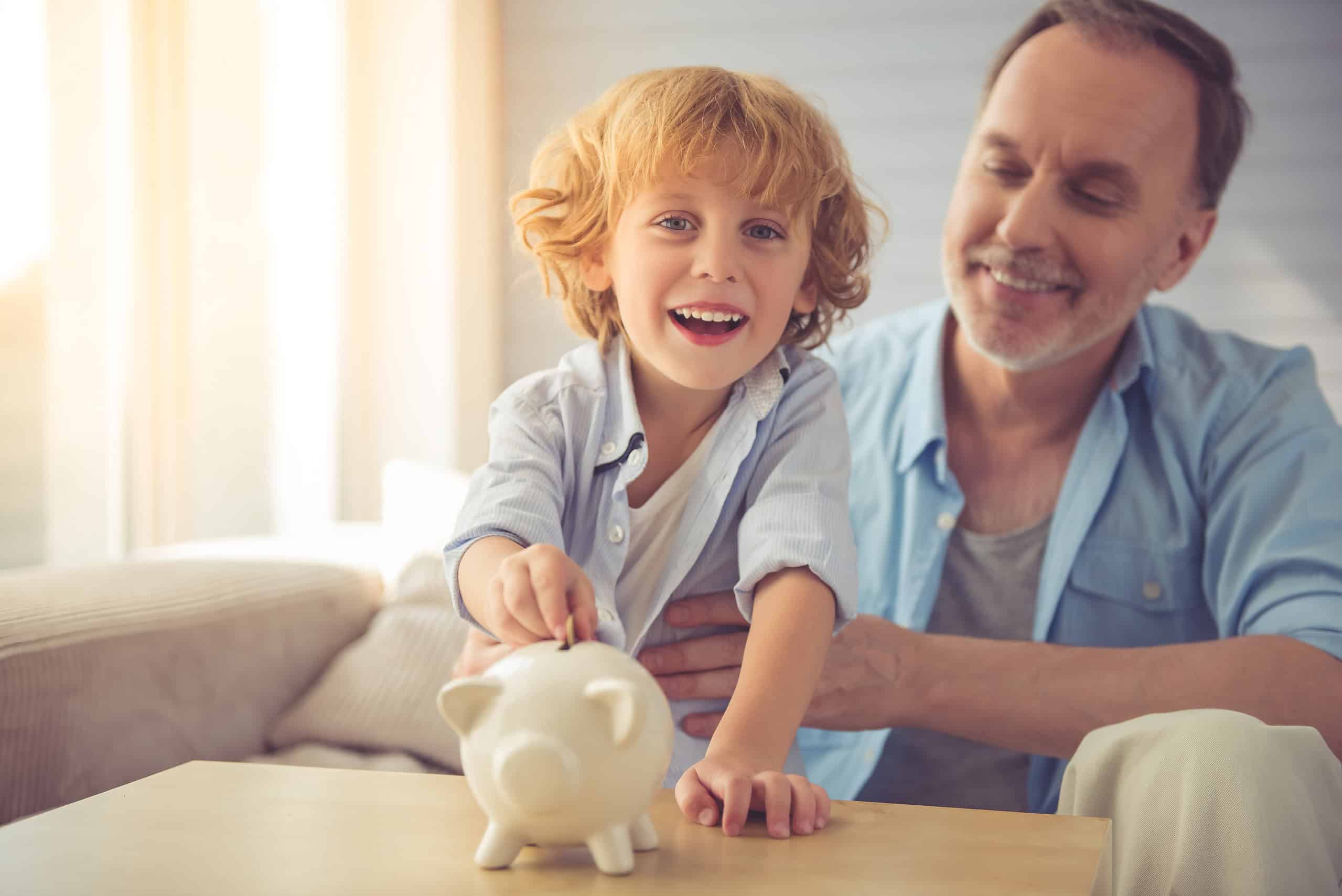 Father with son saving money in piggy bank