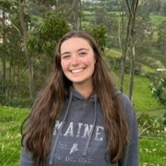 Woman smiling in a wooded area