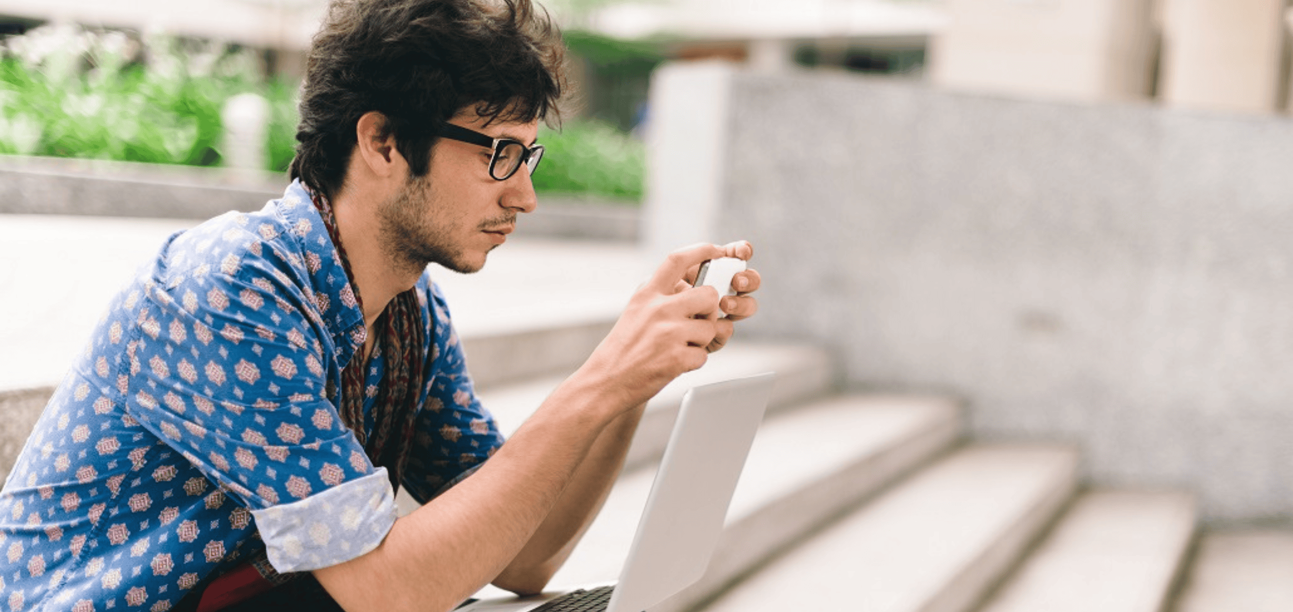 man working with phone and laptop