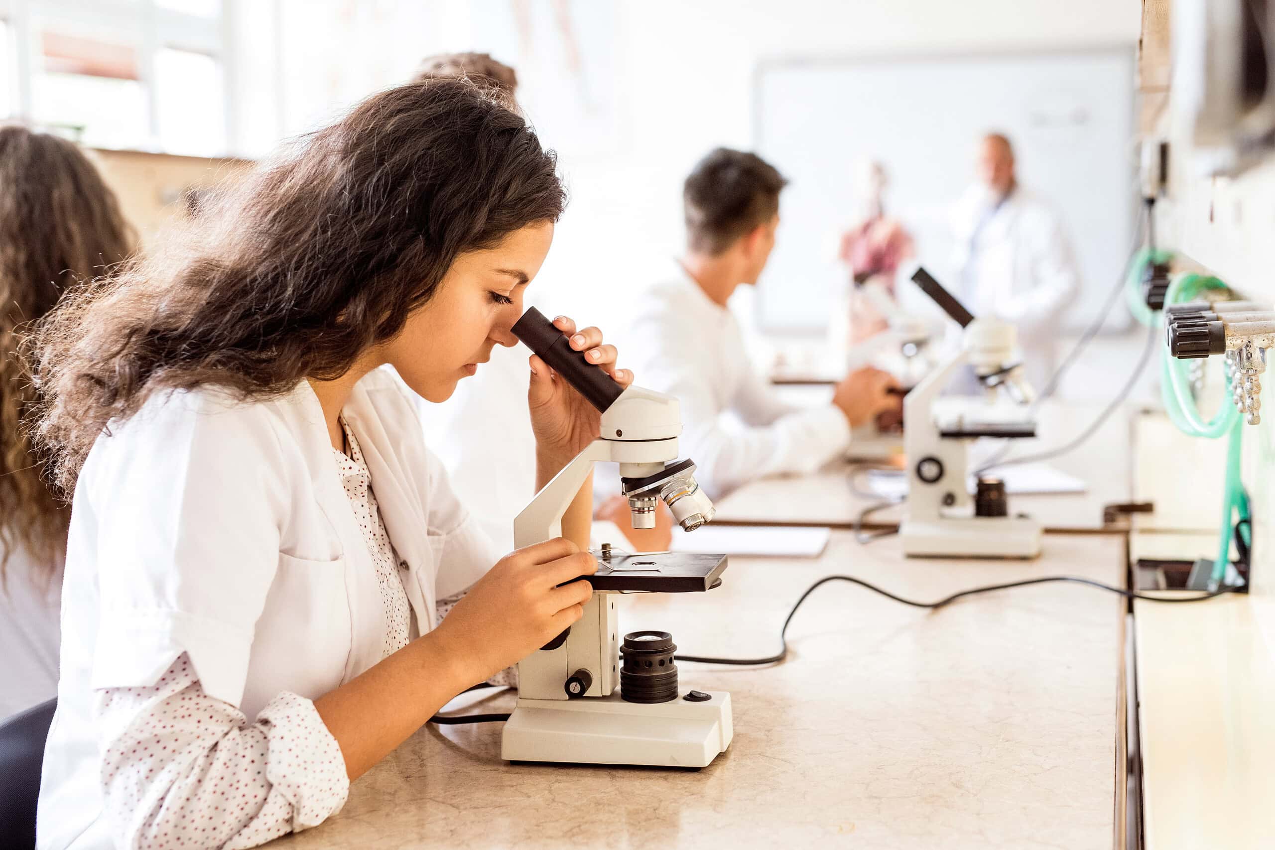 student with microscope in laboratory