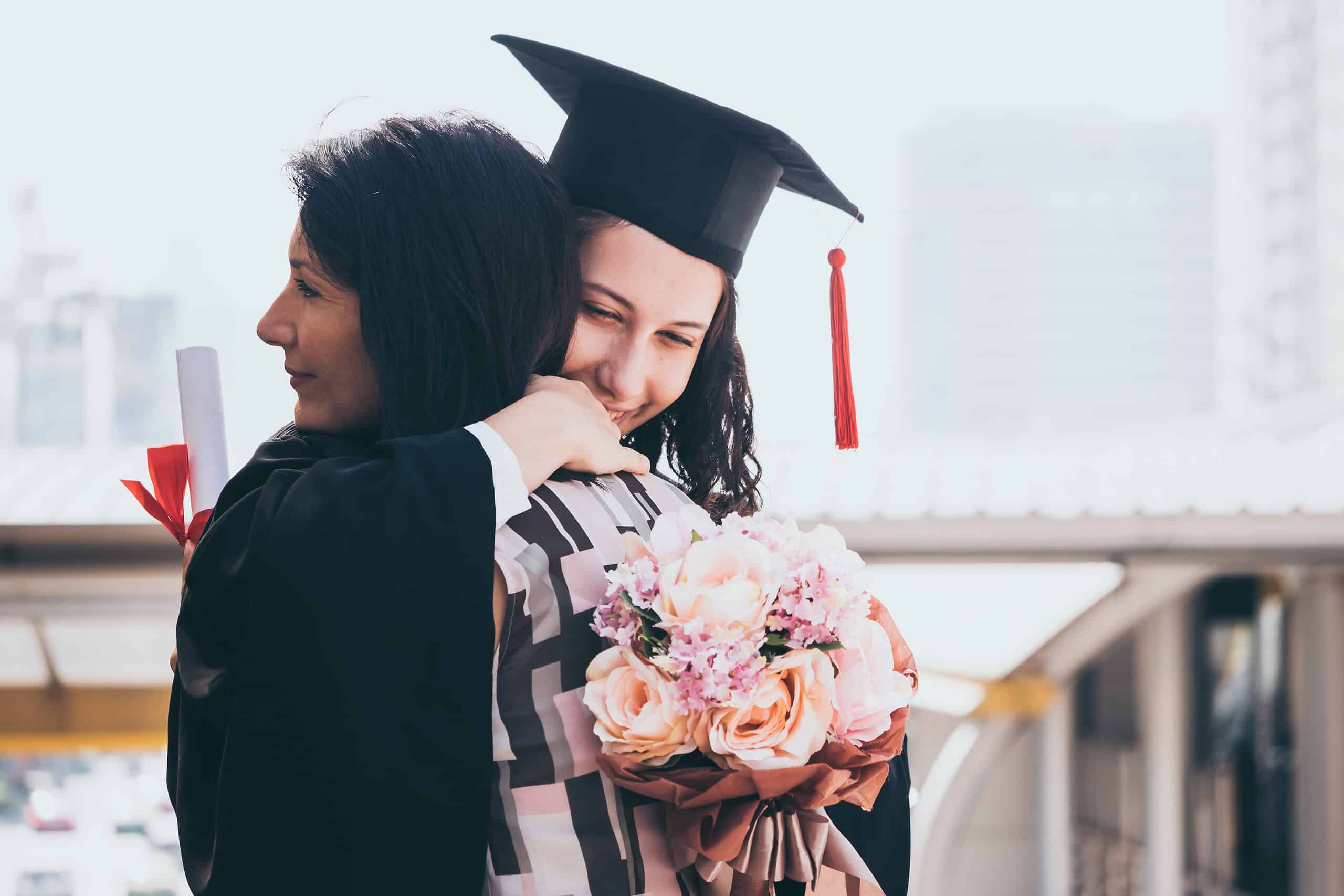graduates hugging a parent