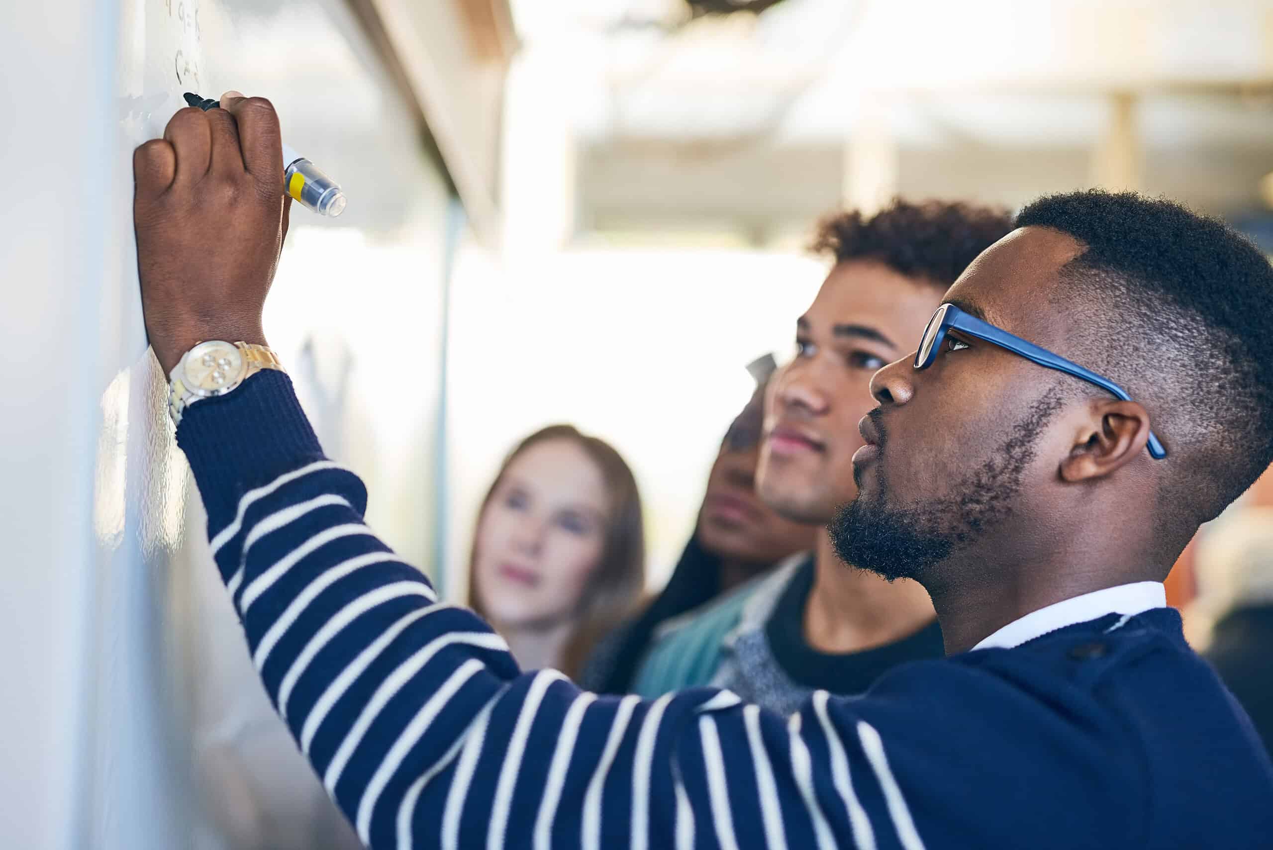 Teacher working with students at a board